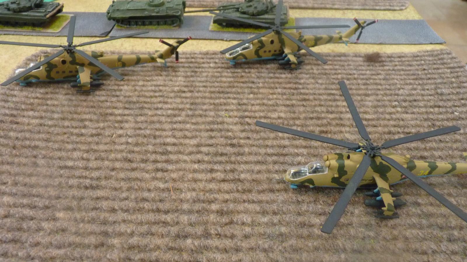 a flight of 3 Mi-24 Hinds at low level over a field